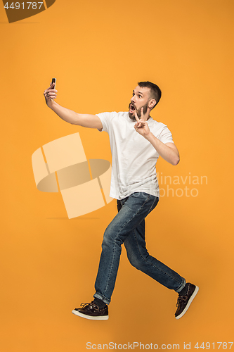 Image of Time to take selfie. Full length of handsome young man taking selfie while jumping