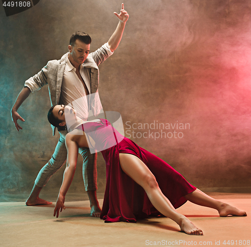 Image of Flexible young modern dance couple posing in studio.