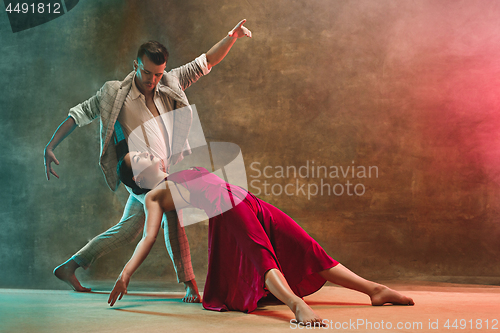 Image of Flexible young modern dance couple posing in studio.