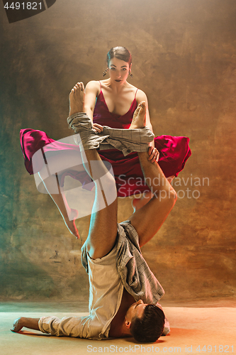 Image of Flexible young modern dance couple posing in studio.