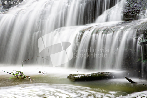 Image of Full flowing waterfall and mossy log