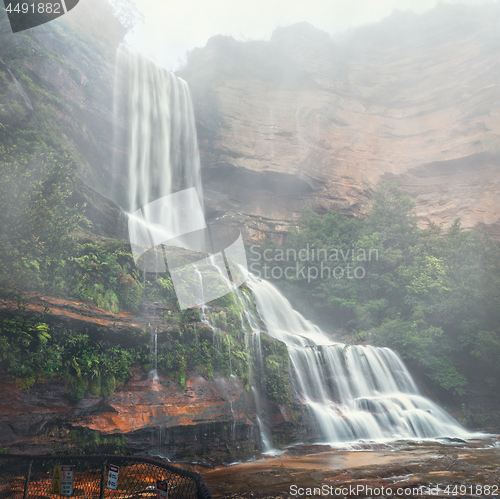 Image of Misty waterfalls tumble down cliffs