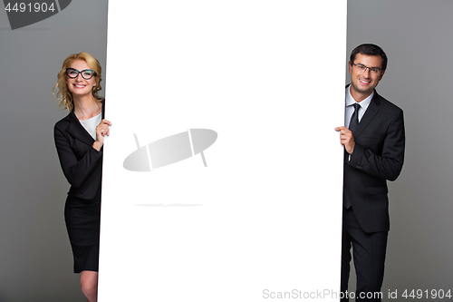 Image of Businessman and business woman with big empty poster