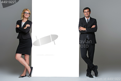 Image of Businessman and business woman with big empty poster