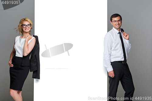Image of Businessman and business woman with big empty poster
