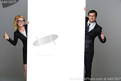 Image of Businessman and business woman with big empty poster