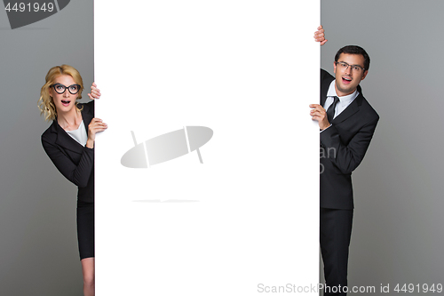 Image of Businessman and business woman with big empty poster