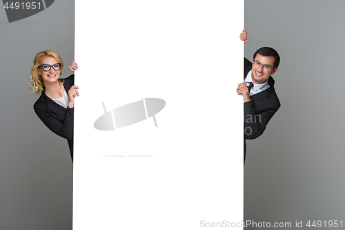 Image of Businessman and business woman with big empty poster