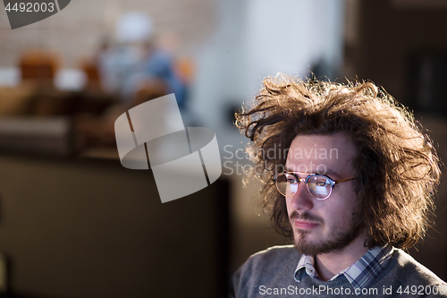 Image of man working on computer in dark office