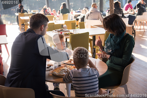 Image of Young parents enjoying lunch time with their children