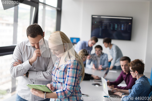 Image of Two Business People Working With Tablet in office