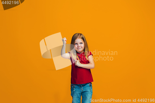 Image of Portrait of angry teen girl on a orange studio background