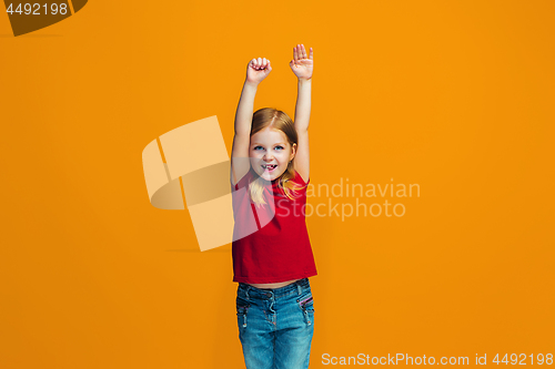 Image of The happy teen girl standing and smiling against orange background.