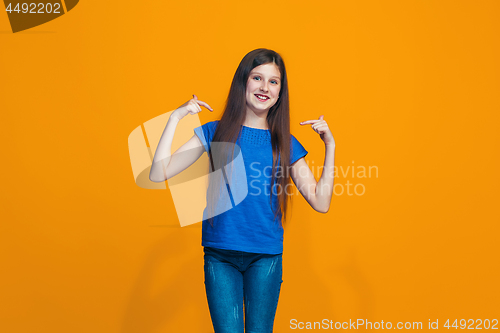 Image of The happy teen girl standing and smiling against pink background.