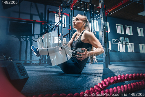 Image of Fit young woman lifting barbells working out in a gym