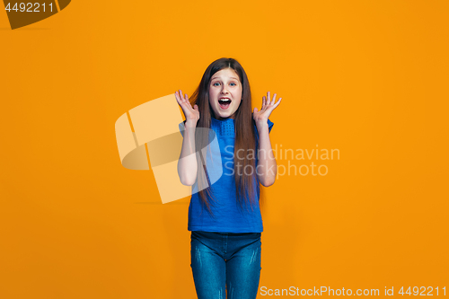 Image of Beautiful teen girl looking suprised isolated on orange