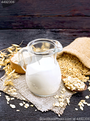 Image of Milk oatmeal in jug on dark wooden board