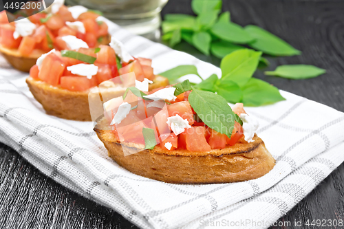 Image of Bruschetta with tomato and feta on board