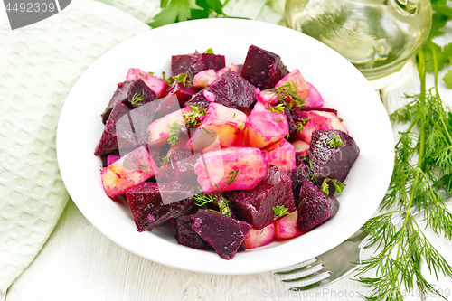 Image of Salad of beets and potatoes in plate on wooden board
