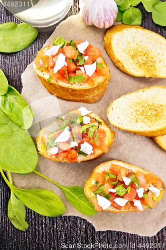 Image of Bruschetta with tomato and cheese on board top