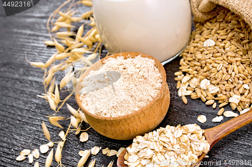 Image of Flour oat in bowl with oatmeal on wooden board