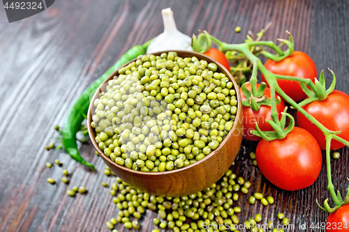 Image of Mung beans  in bowl with vegetables and thyme on dark wooden boa