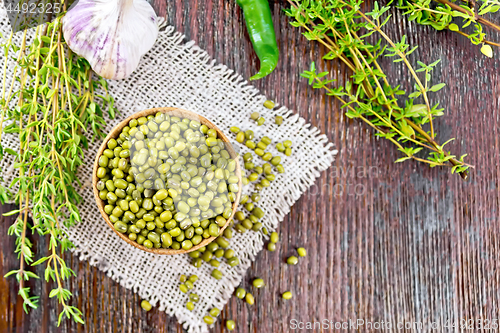 Image of Mung beans in wooden bowl with thyme on board top