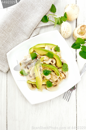 Image of Salad of avocado and champignons on light board top