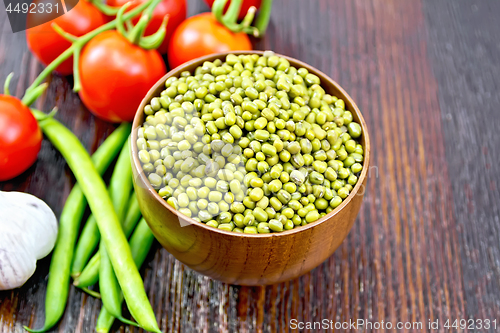 Image of Mung beans  in bowl with vegetables on dark board