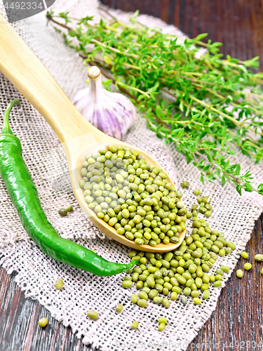 Image of Mung beans in spoon on dark board