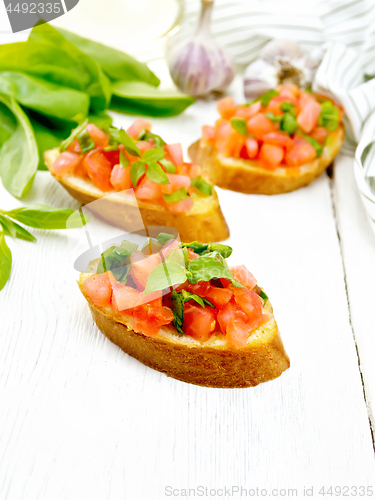 Image of Bruschetta with tomato and spinach on white board