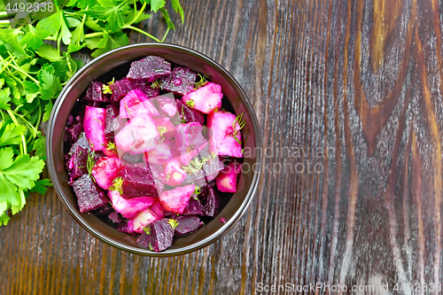 Image of Salad of beets and potatoes with oil in bowl on board top