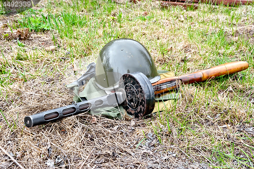 Image of Helmet and submachine gun on ground