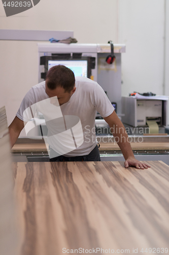 Image of worker in a factory of wooden furniture