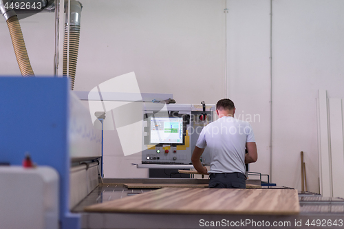 Image of worker in a factory of wooden furniture