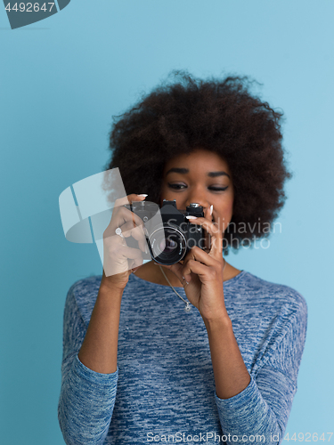 Image of african american girl taking photo on a retro camera
