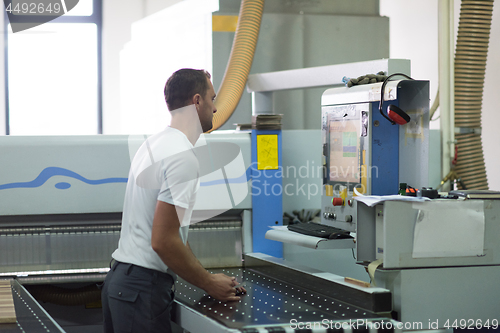 Image of worker in a factory of wooden furniture