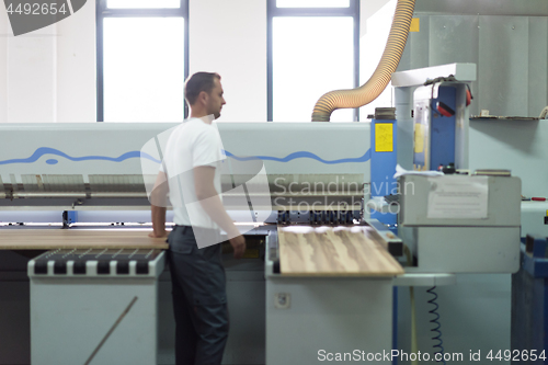 Image of worker in a factory of wooden furniture