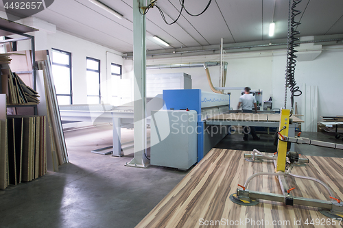 Image of worker in a factory of wooden furniture