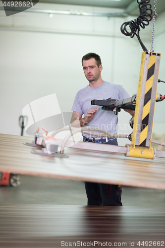 Image of worker in a factory of wooden furniture