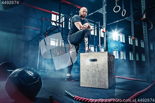 Image of Man standing during exercises in the fitness gym. CrossFit.