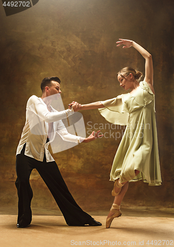 Image of Flexible young modern dance couple posing in studio.