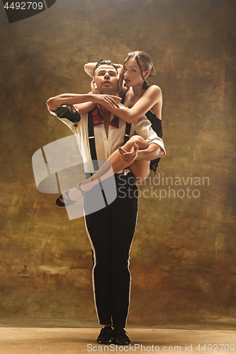 Image of Flexible young modern dance couple posing in studio.