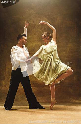 Image of Flexible young modern dance couple posing in studio.