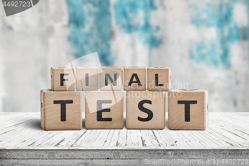 Image of Final test spelled with letter cubes on a wooden table