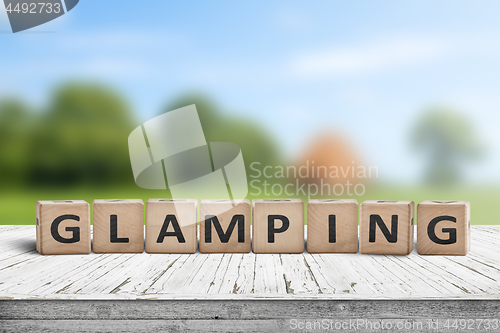 Image of Glamping sign on wooden planks in the summer