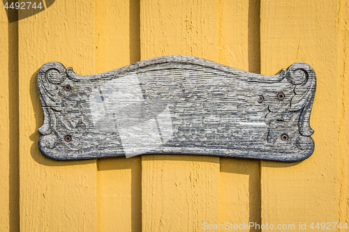 Image of Wooden vintage sign on yellow planked wall