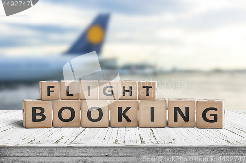 Image of Flight booking sign at an airport with a plane