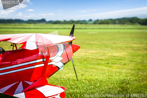 Image of Retro airplane ready to take of on a green field