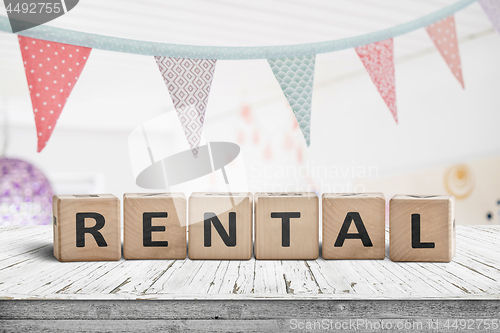 Image of Rental sign with flags hanging over a wooden desk